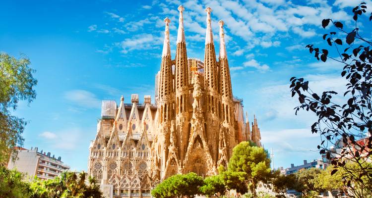 Ikonische Sagrada Família Basilika, die in einen strahlend blauen Himmel mit vereinzelten Wolken in Barcelona ragt.