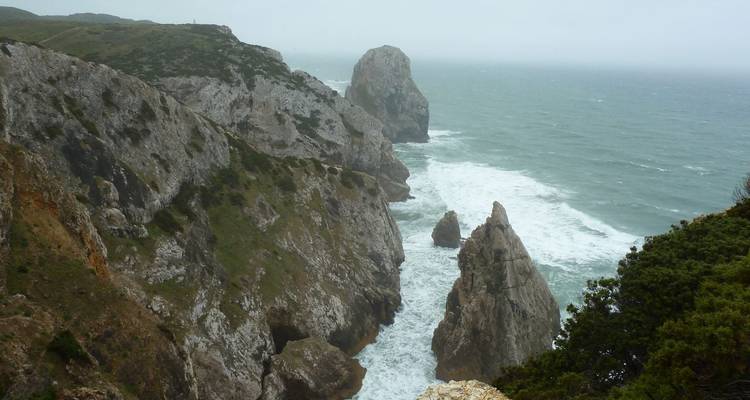 Zerklüftete Meeresfelsen und Felsentürme, die an einem diesigen Tag von rauen Atlantikwellen heimgesucht werden.