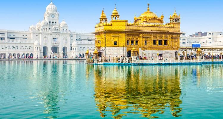 Iconic Golden Temple shimmering in sunlight, its gilded façade reflected perfectly in the sacred pool.