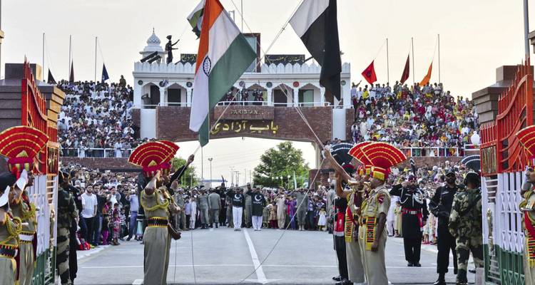 Crowds gather for the Wagah border ceremony as Indian and Pakistani flags are lowered amid colorful military pageantry.