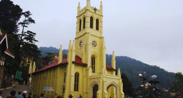 Pale yellow neo-Gothic Christ Church rises above Shimla’s Mall Road against a misty hillside backdrop.