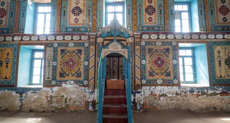 Intérieur peint avec intricacité d'une ancienne mosquée caucasienne présentant des motifs géométriques et floraux colorés.