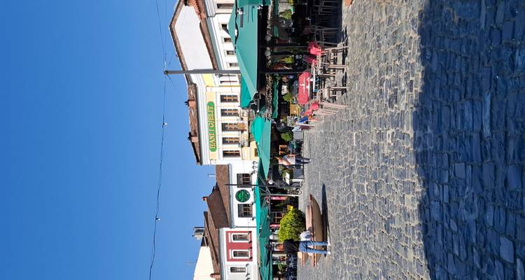 Cobbled square lined with colorful cafés and umbrellas in a historic bazaar district