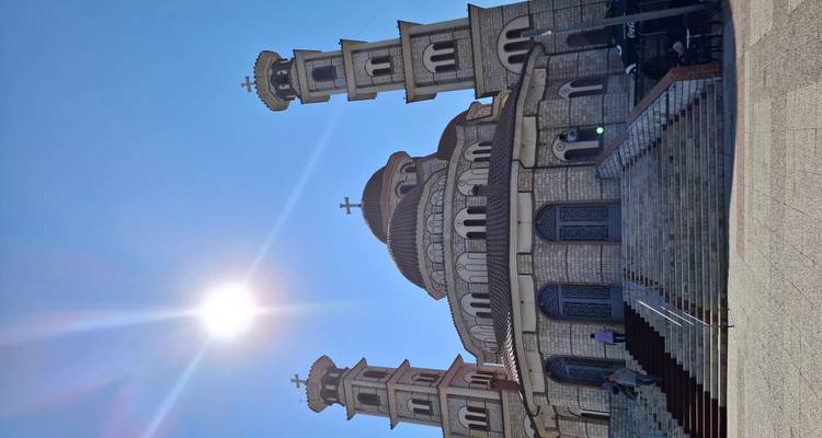 Grand Orthodox cathedral with twin bell towers glowing under a bright sun in blue sky