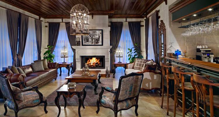 Luxuriöse Lounge mit Kamin, Kronleuchtern und klassischen Möbeln.