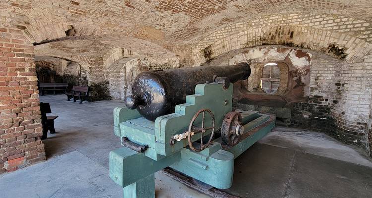 Historic brick casemate housing an old cannon inside Fort Sumter style coastal fortification.