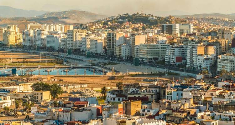 Paysage urbain côtier de Tanger s'étendant du port aux collines environnantes dans la douce lumière de l'après-midi.
