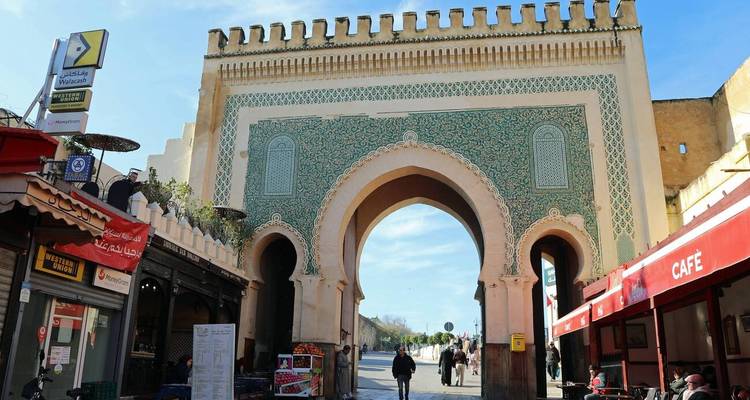 Porte ornée de tuiles vertes Bab Bou Jeloud s'ouvrant sur les rues animées de Fès.