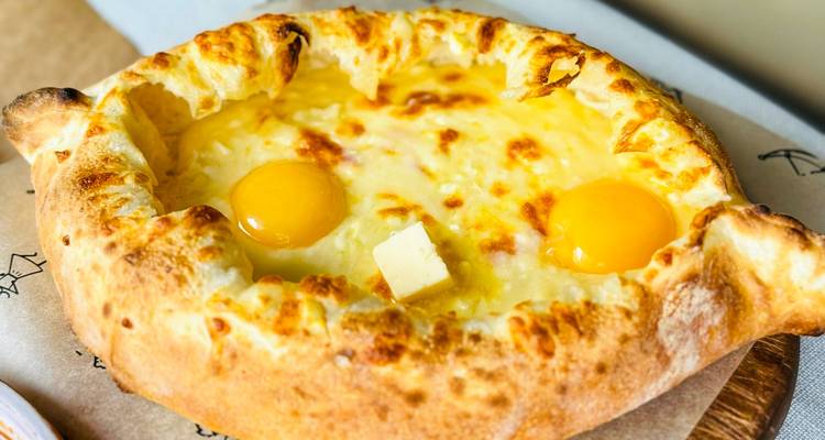 Traditionelles georgisches Käsebrot Khachapuri mit flüssigen Eigelben frisch aus dem Ofen