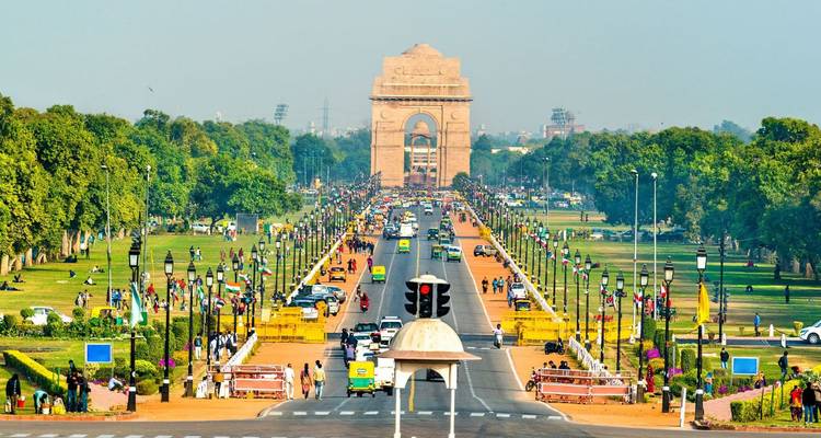 Blick den Rajpath hinunter in Richtung India Gate mit Verkehr, Gärten und Menschenmengen auf beiden Seiten.