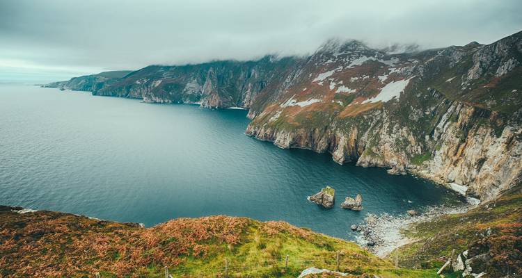 Les terres côtières brumeuses aux falaises vertigineuses plongeant dans les eaux bleu profond le long de la côte de Slieve League