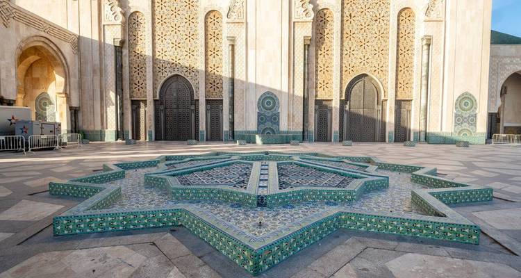 Fontaine mosaïque en forme d'étoile dans la cour de la mosquée Hassan II avec un carrelage géométrique complexe