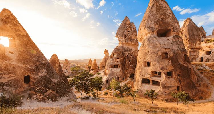 Casas de roca en chimeneas de hadas en Capadocia brillando bajo la luz del sol del final de la tarde.
