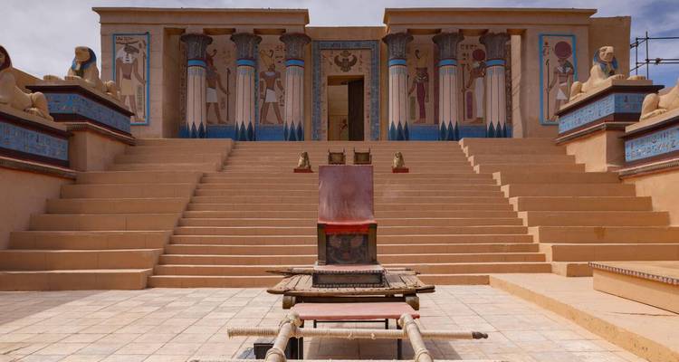 Plateau de studio de cinéma présentant une façade de temple égyptien antique recréée avec des colonnes peintes et un trône
