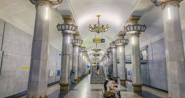 Salle élégante de station de métro de l'époque soviétique avec lustres ornés et voyageurs