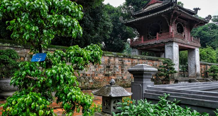 Patio del Templo Histórico de la Literatura enmarcado por bonsáis cuidados y muros antiguos.