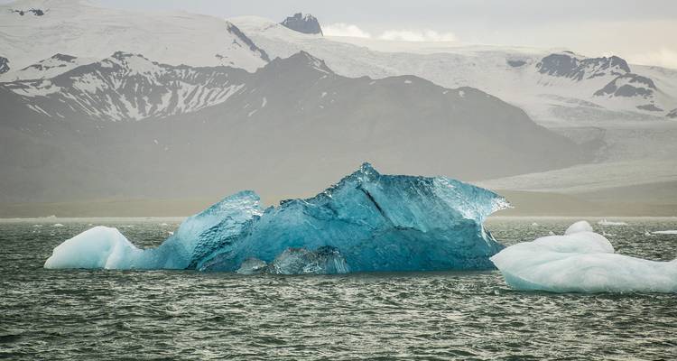Ein leuchtend blauer Eisberg treibt in den Gletscherwassern der Jökulsárlón-Lagune.