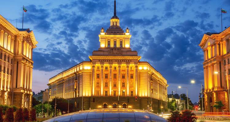 Verlicht voormalig Partijhuis gebouw in Sofia gloeiend tegen een dramatische avondhemel