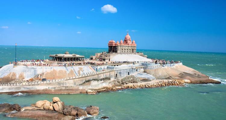 Menigten die het Vivekananda Rock Memorial bezoeken dat oprijst uit de zee onder een heldere blauwe hemel.