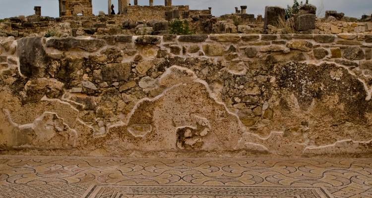 Alte Steinmauer und verzierter römischer Mosaikboden in der Ruinenstadt Volubilis