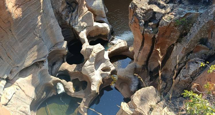 Vista aérea de los Pozos de la Suerte de Bourke mostrando formaciones rocosas cilíndricas suaves llenas de agua.