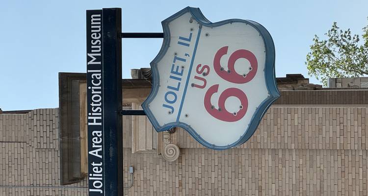 Réplique d'un panneau de la Route 66 américaine devant le Musée historique de la région de Joliet par une journée ensoleillée.