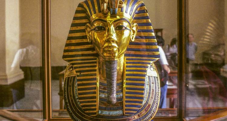 Golden funerary mask of Tutankhamun displayed inside a glass case at the Egyptian Museum.