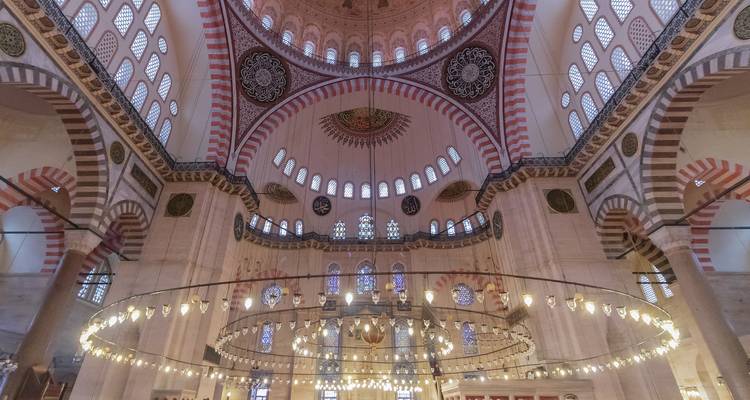 Interior opulento de la Mezquita de Süleymaniye con grandes cúpulas y caligrafía ornamentada