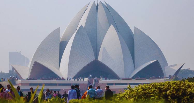 Der moderne Lotus-Tempel in Delhi erhebt sich wie eine Marmorblüte über gepflegten Gärten voller Besucher.
