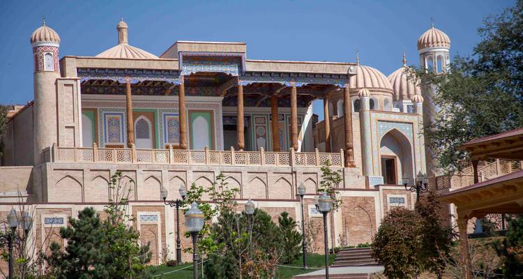 Élégant bâtiment palatial avec colonnade en bois et accents carrelés se dressant contre un ciel sans nuages.