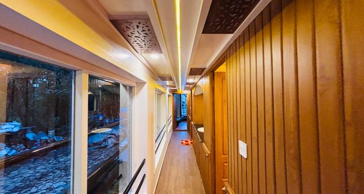 A wooden-paneled corridor with windows runs the length of the houseboat interior.