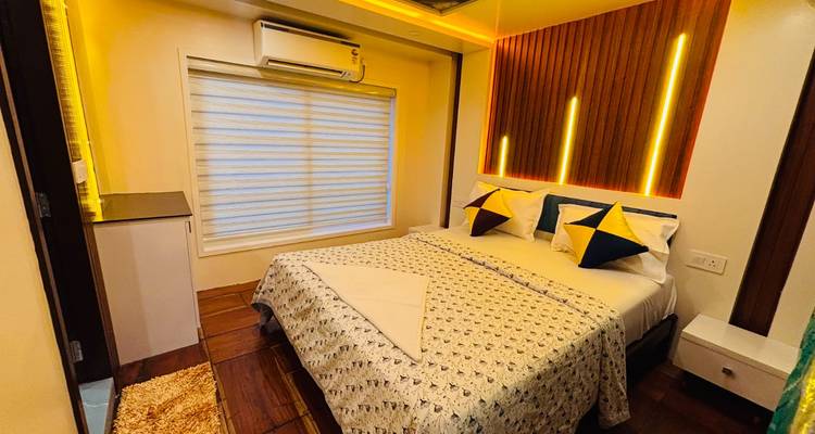 A cozy bedroom on the houseboat features patterned bedding, accent lighting and a large window.