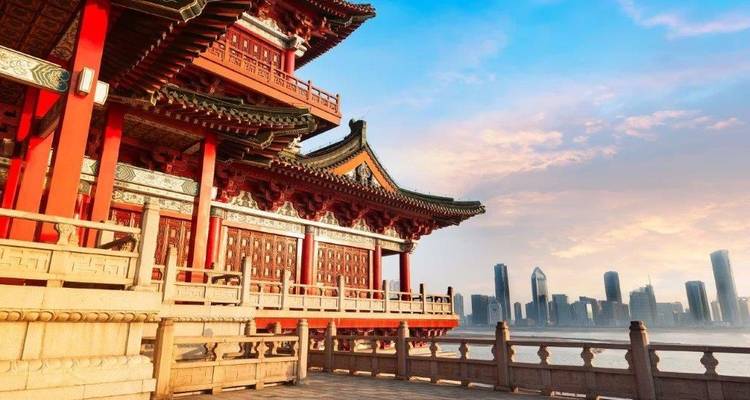 Traditioneel rood Chinees paviljoen met uitzicht op een moderne skyline van de stad aan het water