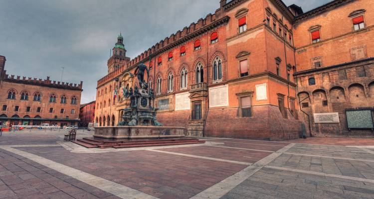 La Fontaine de Neptune domine la Piazza del Nettuno de Bologne avec ses palais médiévaux qui s'illuminent au crépuscule.
