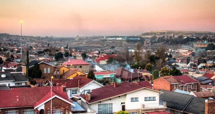 Sweeping sunset view over the rooftops and streets of a Johannesburg suburb.