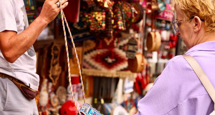 Shoppers examine colorful handicrafts at a bustling outdoor market stall