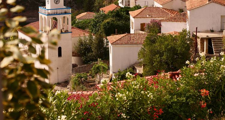 Charming Mediterranean village with a white church tower, terracotta roofs, and blooming gardens
