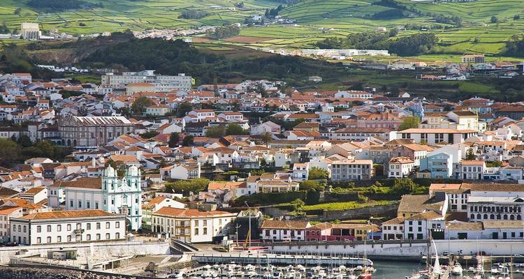 Harbor town with whitewashed buildings and church rising above the marina in Faial