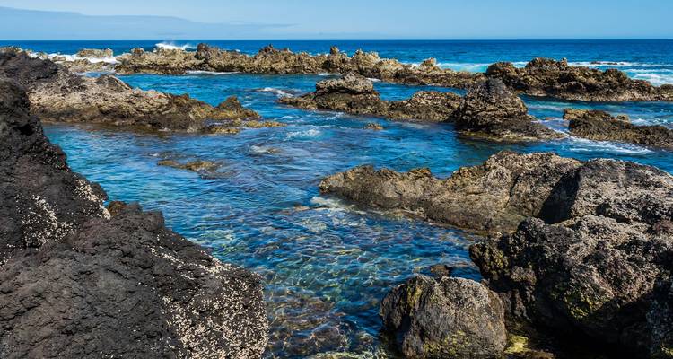 Clear tidal pools amid rugged black lava rocks on the Atlantic coast