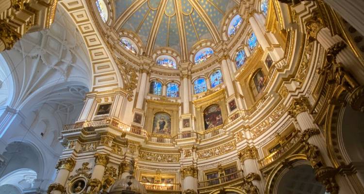 Prächtige goldene Innenkuppel und Galerien einer großartigen spanischen Kathedrale, beleuchtet durch natürliches Licht.