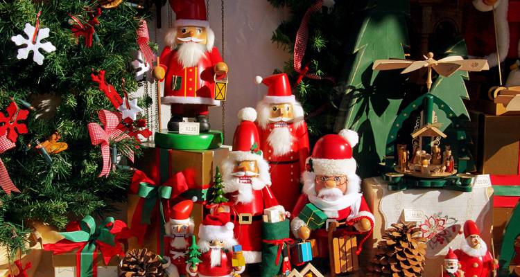 Colorful display of handcrafted nutcracker figurines, pinecones and festive decorations at a Christmas market stall.