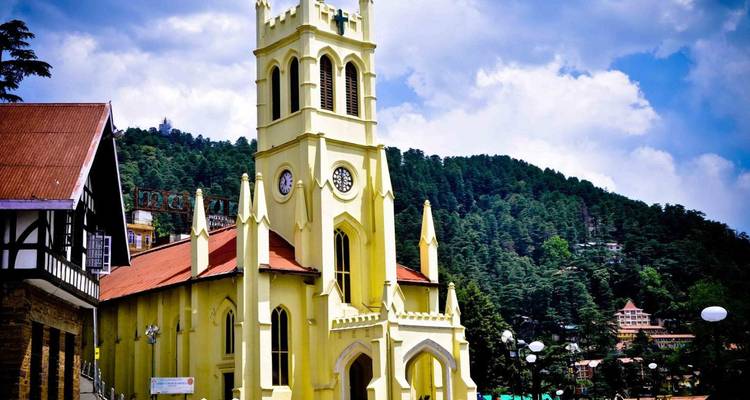 The pale yellow neo-Gothic Christ Church rises above Shimla’s Mall Road with pine-covered hills in the background.