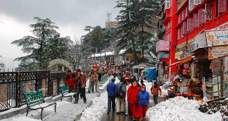Snow-covered Shimla Mall Road bustles with brightly dressed locals and tourists between colourful shops and pines.