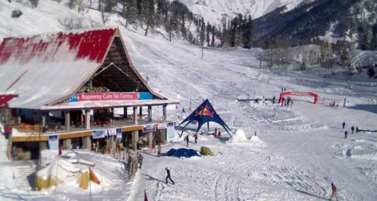 A snowy ski centre with skiers, lifts and a chalet-style lodge in a wide white valley.