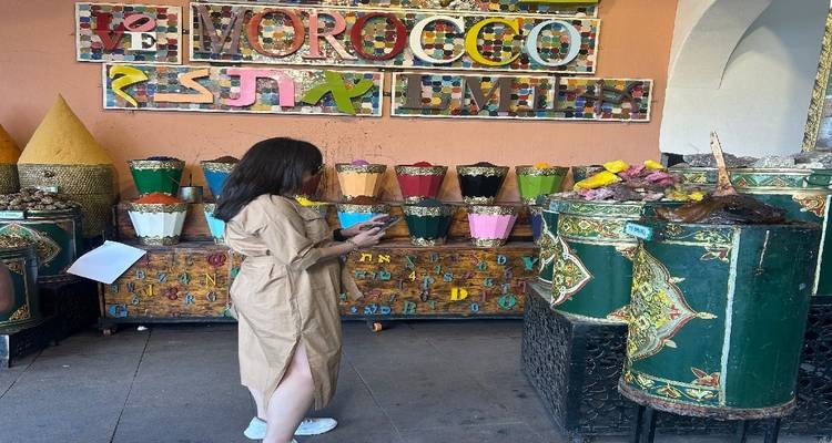 Woman browsing colorful spice cones and crafts in Moroccan market shop