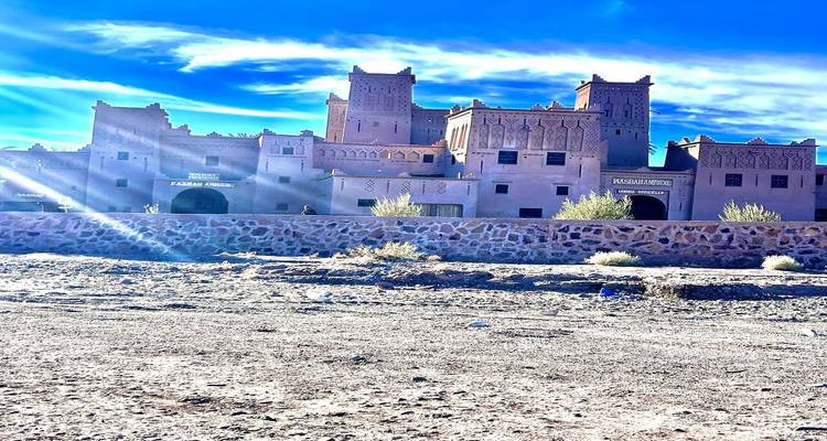 Large kasbah-style hotel complex with crenellated towers under blue sky