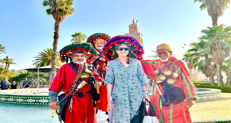 Toerist met traditionele Marokkaanse waterverkopers in kleurrijke kleding bij fontein