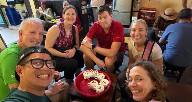 Travel group samples local desserts served in small cups at a cozy Vietnamese café.
