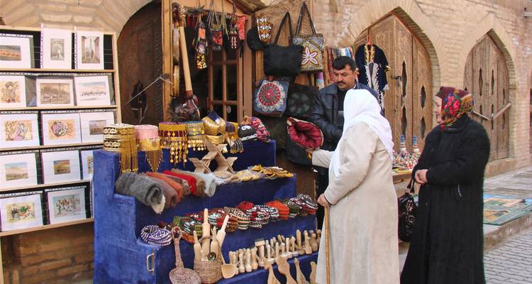 Lokale vrouwen die kleurrijke handwerkstallen bekijken in een historische bazaarsteeg.