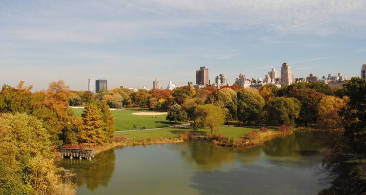 Vista otoñal del lago de Central Park con el horizonte de Manhattan a lo lejos.